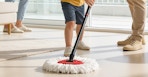a person mopping the floor with a spin mop