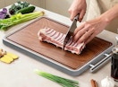 a person cutting food on a cutting board