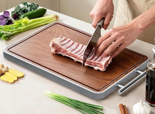 a person cutting food on a cutting board