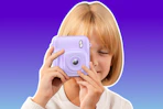 child holding a purple instant print camera