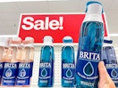 brita filter water bottles on shelf in front of sale sign with one being held