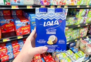 hand holding lala yogurt smoothies in front of other yogurt products