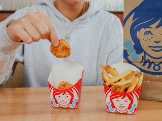 a person grabbing a nugget from wendys