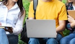 a group of friends around a laptop