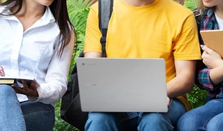 a group of friends around a laptop