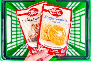 hand holding up betty crocker baking mixes above green basket