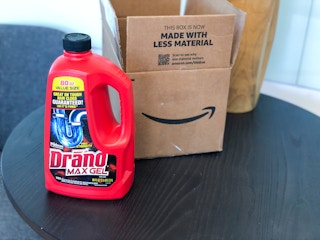 a bottle of Drano sitting in front of an Amazon box