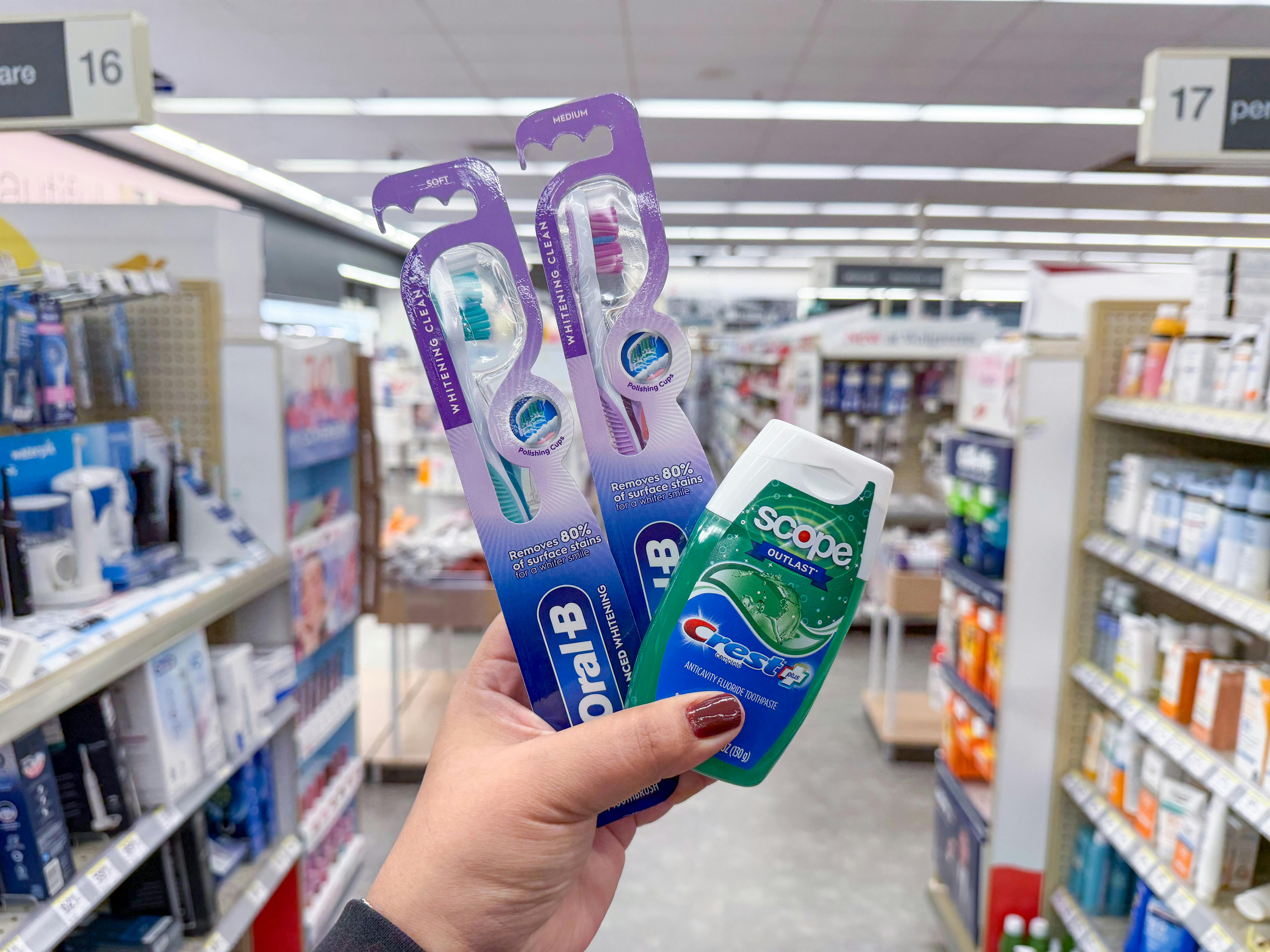 hand holding crest and oral-b products in walgreens