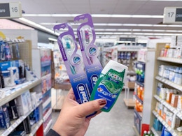hand holding crest and oral-b products in walgreens