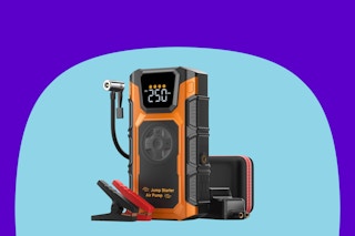 A black and orange jump starter and tire inflator combo. Two clamps and an air tube are part of the rectangular charger w digital display
