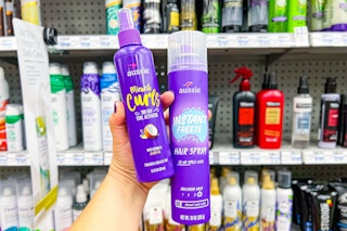 hand holding aussie curls mousse and hairspray