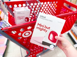 hand holding a cricut easypress mini in front of a target cart