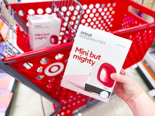hand holding a cricut easypress mini in front of a target cart