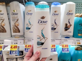 hand holding a bottle of dove shampoo at kroger