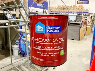 hand holding gallon of hgtv sherwin-williams paint in lowes store