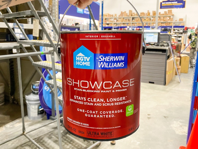 hand holding gallon of hgtv sherwin-williams paint in lowes store