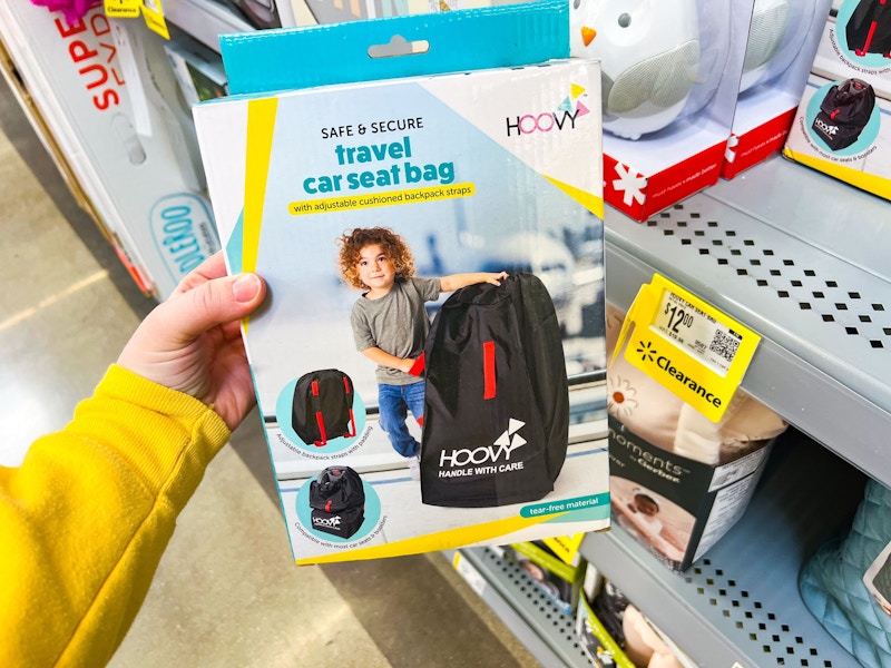 hand holding hoovy travel car seat bag at walmart
