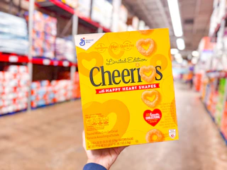 hand holding me a box of general mills cereal