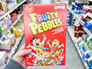 hand holding fruity pebbles cereal in walgreens
