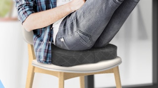 a person sitting on a cushion in a seat