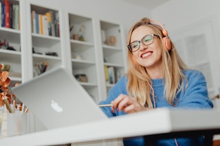 a woman with headphones on at a computer