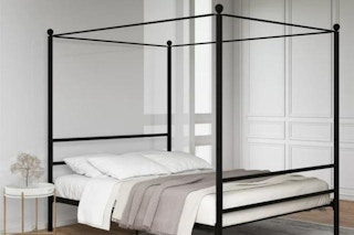 lifestyle image of a black metal canopy bed in a bedroom