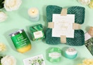 a green-themed spa gift set on a mint green background with flowers