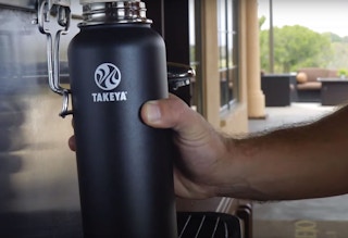 A man filling up a Takeya water bottle.