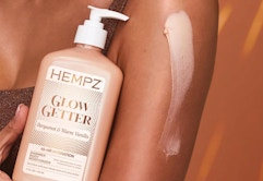 a bottle of lotion next to someone's arm 