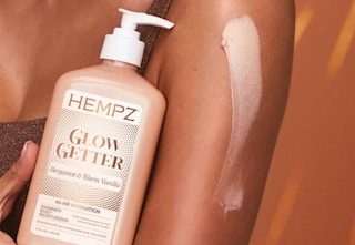 a bottle of lotion next to someone's arm 