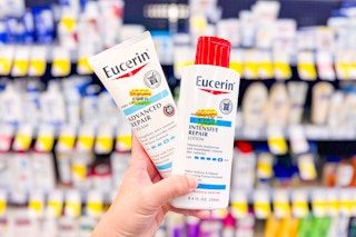 person holding 2 bottles of eucerin lotion