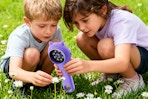 two kids using a microscope to look at flowers