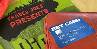 ebt card and wallet on top of trader joes reusable shopping bag