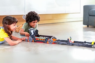 Lifestyle image of the Hot Wheels RacerVerse Batman’s Escape Chase Track Set being played with by 2 children