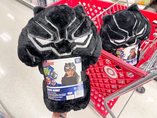 A Black Panther hooded towel held out by hand in front of a Target shopping cart with another Black Panther hooded towel sitting in a ...