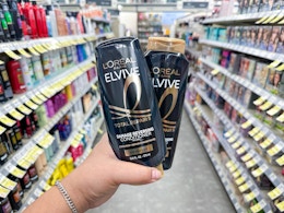 hand holding l'oreal elvive shampoo in walgreens