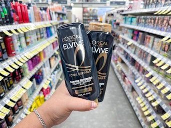 hand holding l'oreal elvive shampoo in walgreens