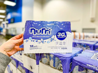 hand touching a pack of nurri protein milk shakes