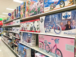 A view down the bike and scooter aisle at Target, with boxes for Frozen and LOL Surprise Doll character bikes in the foreground.