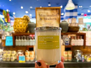hand holding up a single wick candle in store at bath and body works