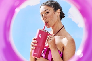 a woman drinking from a hydro flask