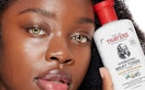 woman holding a bottle of thayers milk toner near her face