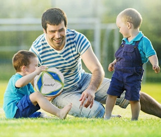 a dad and kids playing with a soccer ball
