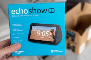 A hand holding an Amazon Echo Show 5 box