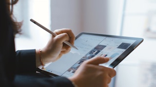 A person using an iPad and Apple pencil for an Adobe project.