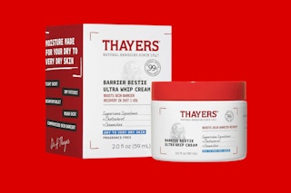 a red and white jar of face cream next to it's packaging