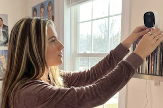 a woman adjusting a camera