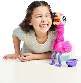 A little girl smiling near a Gotta Go Flamingo toy.