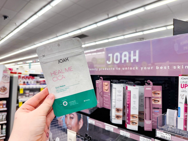person holding a package of acne patches in front of the display