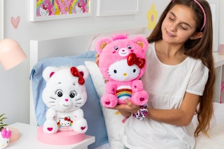 a young girl holding up the collectable hello kitty care bears